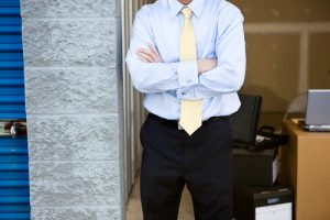 man in front of storage unit with office equipment in storage