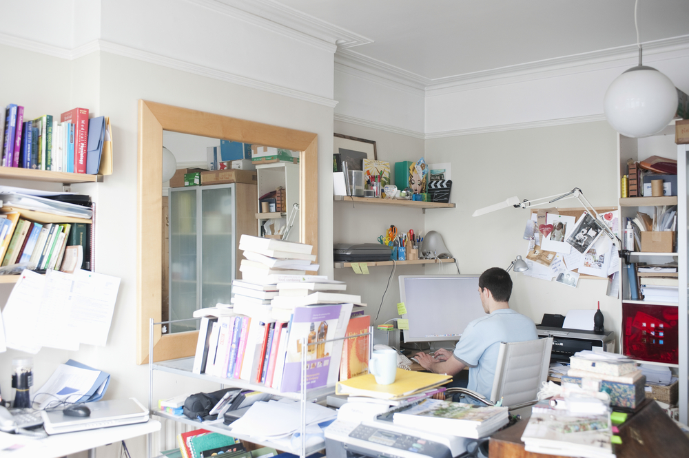 man at home cluttered office